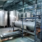 Sistema de controle de nível em tanques industriais de aço inox, com sensores e equipamentos automatizados para monitoramento de líquidos.
