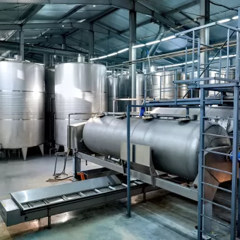 Sistema de controle de nível em tanques industriais de aço inox, com sensores e equipamentos automatizados para monitoramento de líquidos.