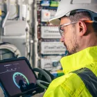 Técnico de instrumentação industrial analisando dados de sensores em painel de automação para garantir precisão do processo