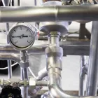 Medidor de vazão industrial instalado em tubulação de aço inox com instrumentação de processo