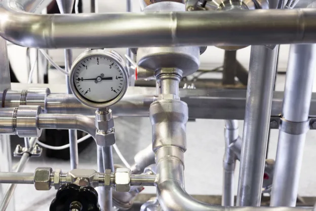 Medidor de vazão industrial instalado em tubulação de aço inox com instrumentação de processo