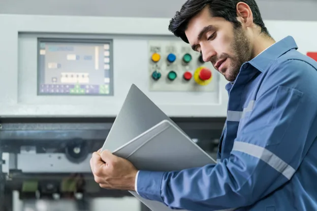 Técnico analisando medidor de vazão em painel de controle industrial